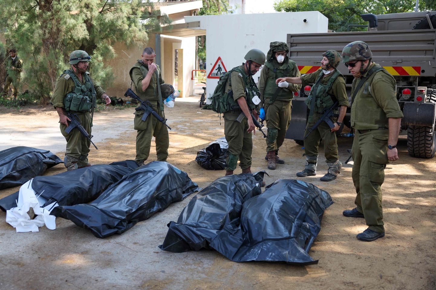 Израильские солдаты готовятся к вывозу тел погибших в кибуце Кфар-Аза.