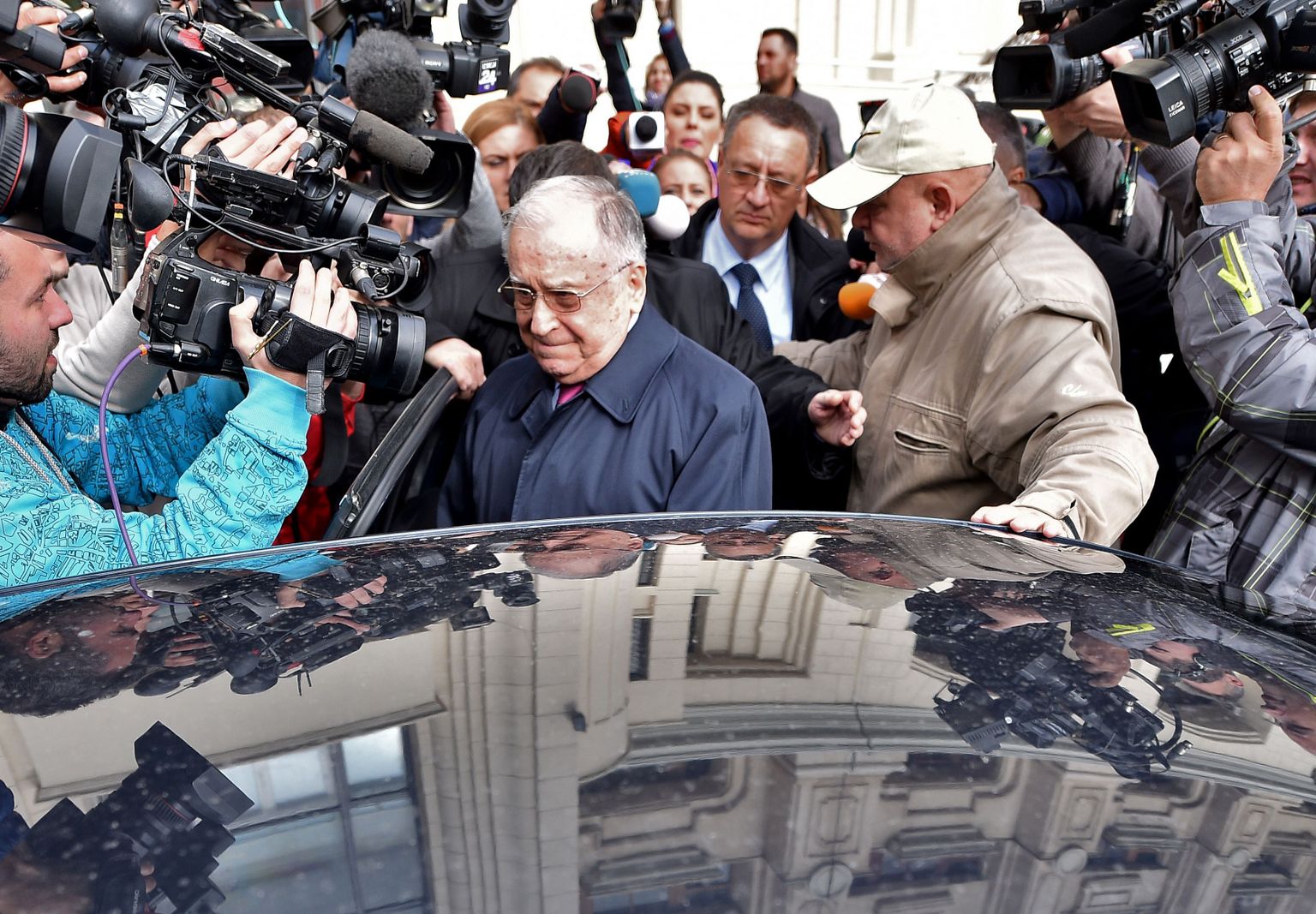 Экс-президент Румынии Ион Илиеску покидает суд после допроса.