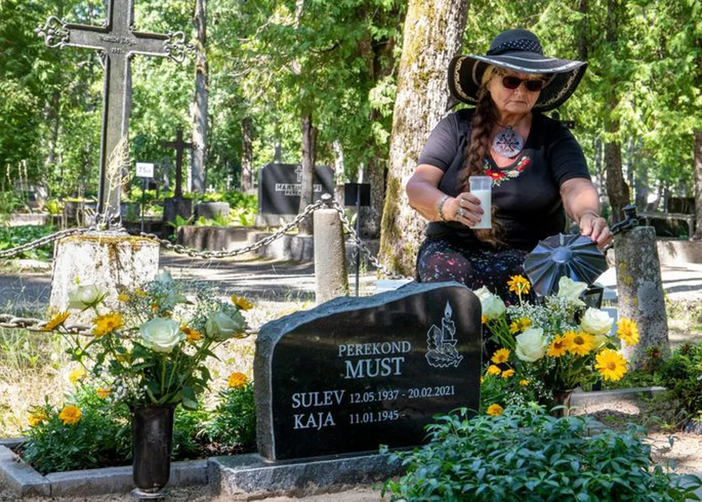 Вдова ставит свечи на могиле мужа. На табличке есть и ее имя, но скоро могильную плиту могут убрать.