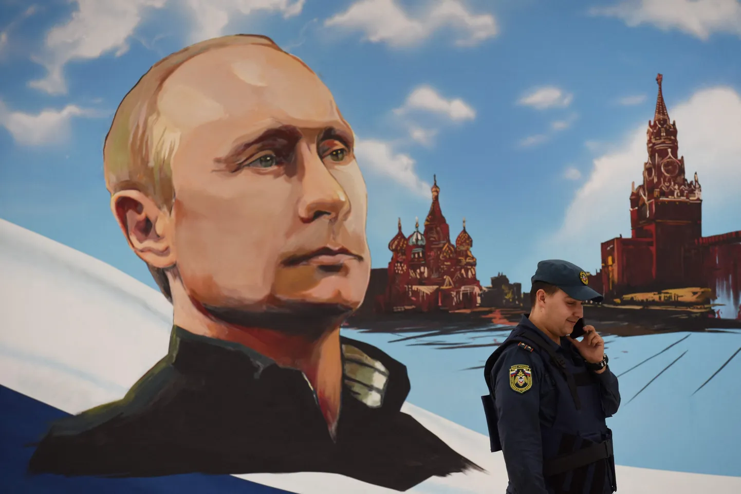 Vene päästeteenistuja räägib mobiiltelefoniga suure Venemaa presidendi plakati taustal, mis riputati üles selle aasta sügisel toimuvate kohalike valimiste ajaks.