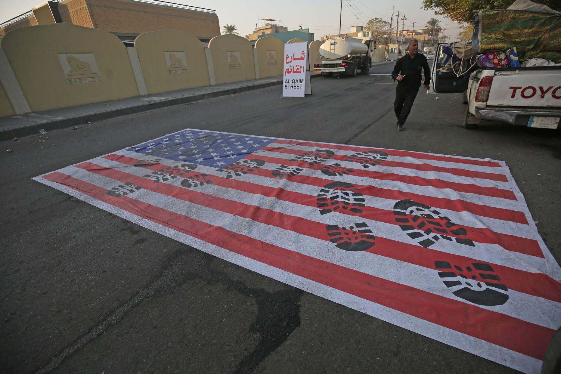 После сообщения об убийстве Сулеймани в Багдаде на асфальт положили американский флаг, который переехали.