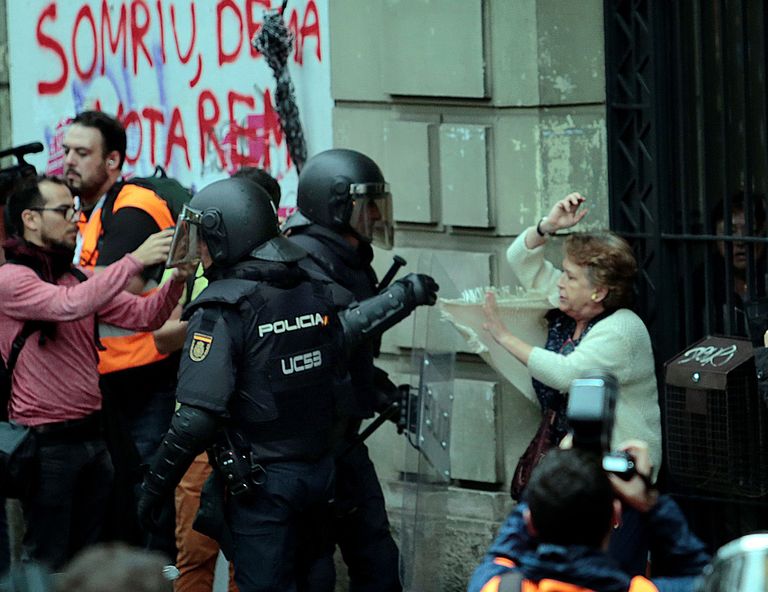 Испанский полицейский дерется с пожилой каталонкой в Барселоне. / Scanpix