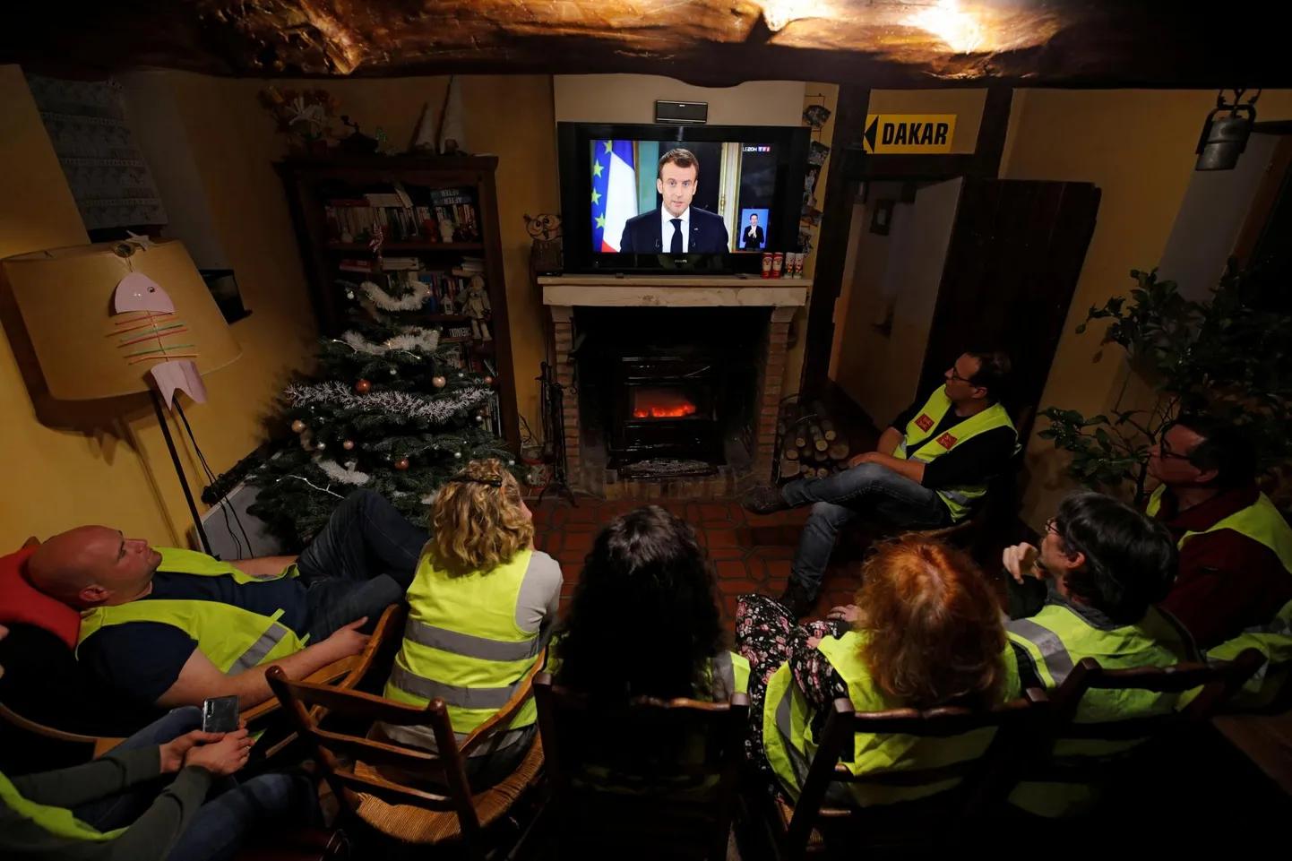 Kollast vesti kandvad protesteerijad vaatavad televiisorist Prantsusmaa presidendi Emmanuel Macroni pöördumist rahvale seoses nädalaid kestnud meeleavaldustega.