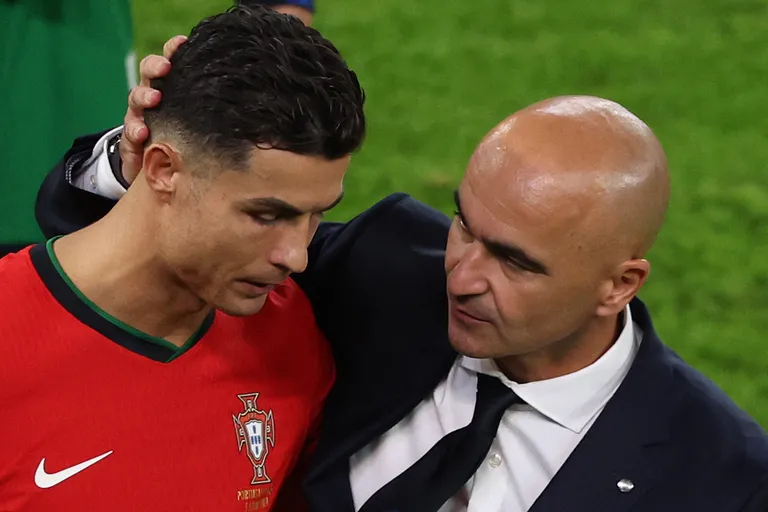 Portugali koondise peatreener Roberto Martinez (paremal) lohutab kaotuse järel Cristiano Ronaldot.