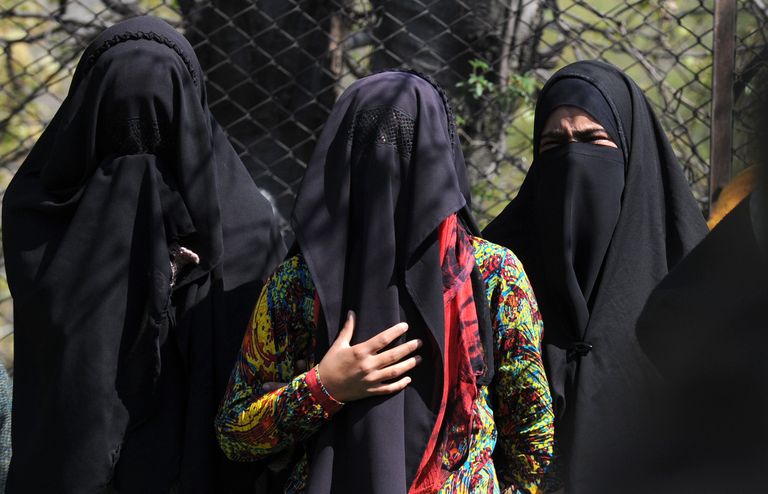 Kashmiri women watch as villagers carry the body of muslim youth, Khalid Wani during his funeral in Tral, south of Srinagar on April 14, 2015.  Wani was killed during an operation in the nearby woods on April 13 by Indian army soldiers, who claimed that Wani, brother of a rebel commander, was a "terrorist".  Local residents alleged the slain youth was among three persons waylaid by army troops and shot dead. The killing sparked protests in the area leading to clashes with Indian police.    AFP PHOTO / Tauseef MUSTAFA