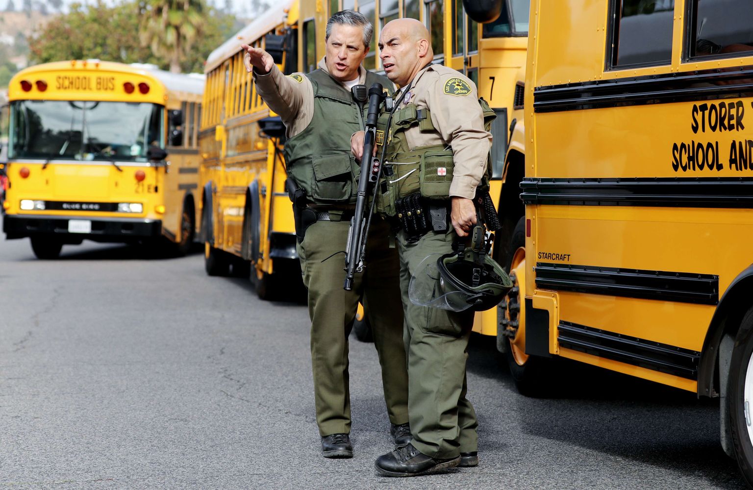 Los Angelese korrakaitsjad koolibusside kõrval.
