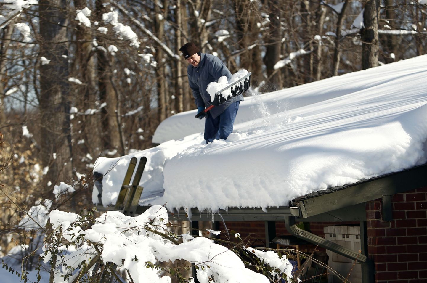 Mees roogib katuselt lund.