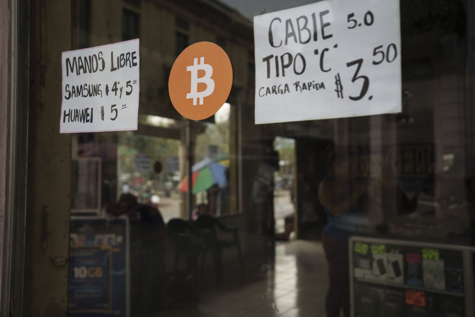 A Bitcoin sign is displayed at a cell phone store in San Salvador, El Salvador, Wednesday, Feb. 2, 2022. The government of El Salvador on Monday rejected a recommendation by the International Monetary Fund to drop Bitcoin as legal tender in the Central American country. (AP Photo/Moises Castillo)