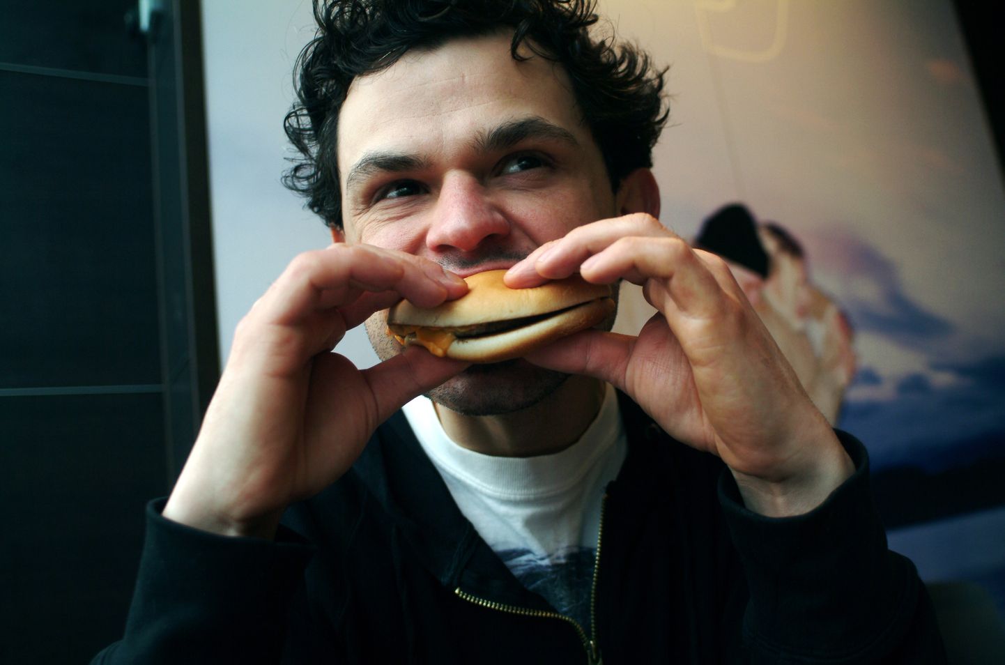 Pilt on illustreeriv: mees sööb McDonald'sis burgerit.