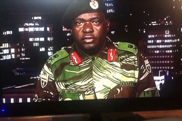 TOPSHOT - This screen grab taken early on November 15, 2017 from a television broadcast on the Zimbabwe Broadcasting corporation (ZBC) shows Zimbabwe Major General Sibusiso Moyo reading a statement at the ZBC broadcast studio in Harare.
Zimbabwe's military appeared to be in control of the country on November 15 as generals denied staging a coup but used state television to vow to target "criminals" close to President Robert Mugabe. / AFP PHOTO / Dewa MAVHINGA