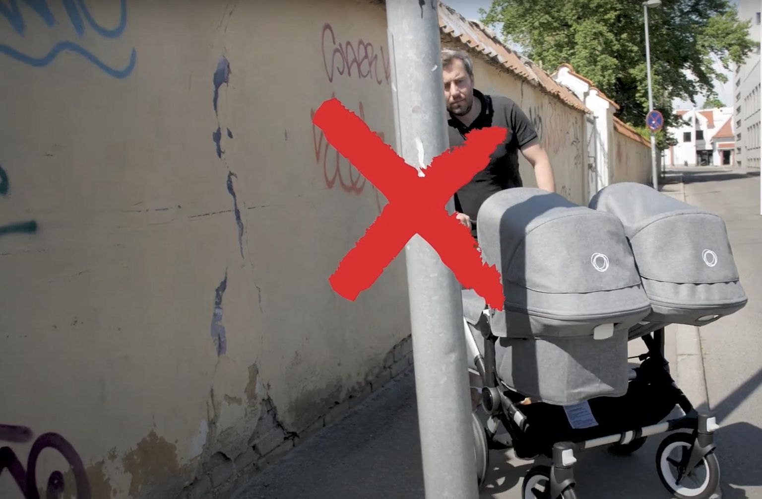 Kaader teavituskampaania klipist teleajakirjanik Roald Johannsoniga: keset kõnniteed püstitatud postid teevad tee lapsevankriga läbimatuks.