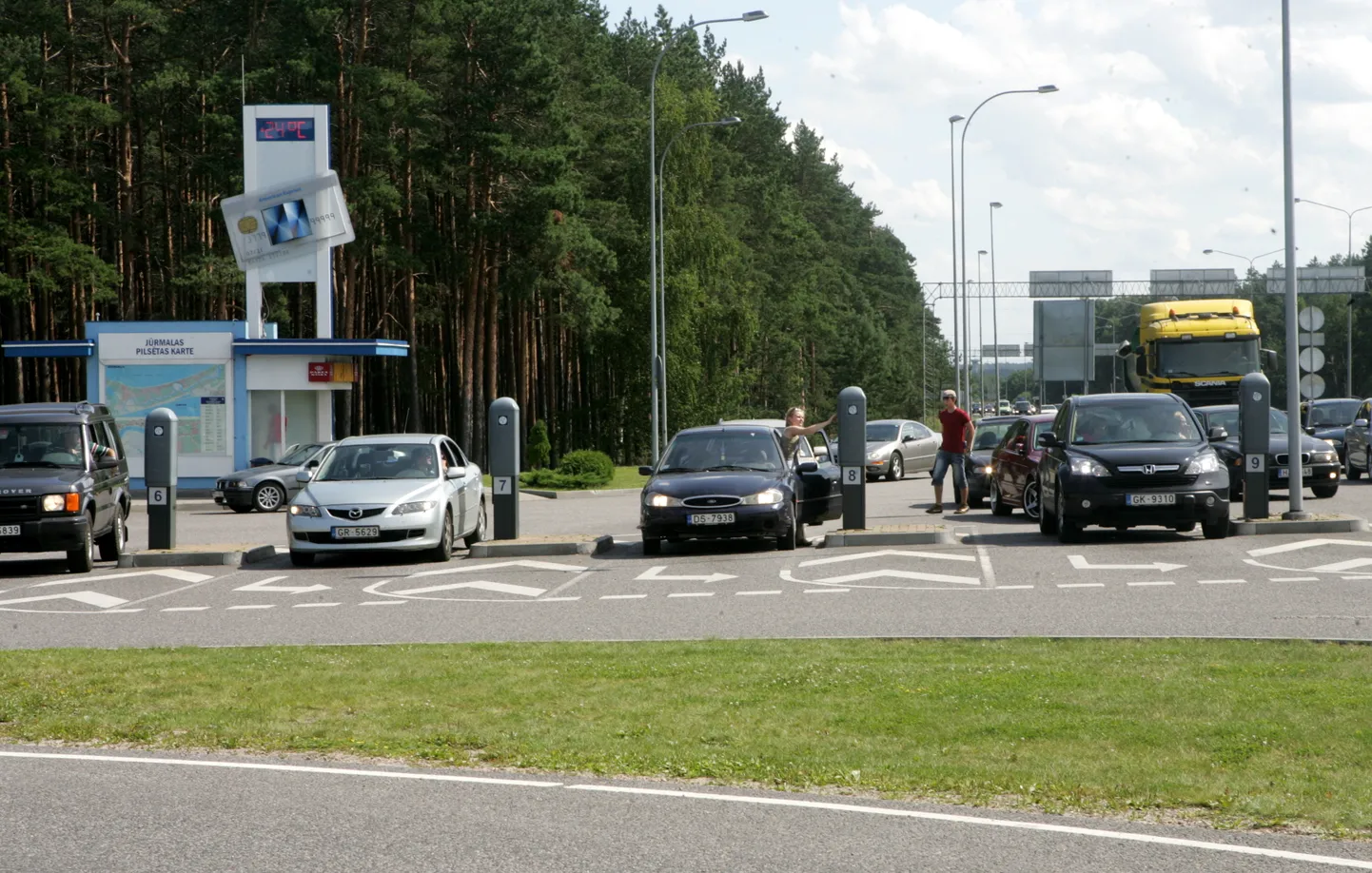 Cilvēki iegādājas autotransporta caurlaides iebraukšanai Jūrmalas pilsētas īpaša režīma zonā kontrolpunktā Priedainē pirms iebraukšanas pilsētā.
