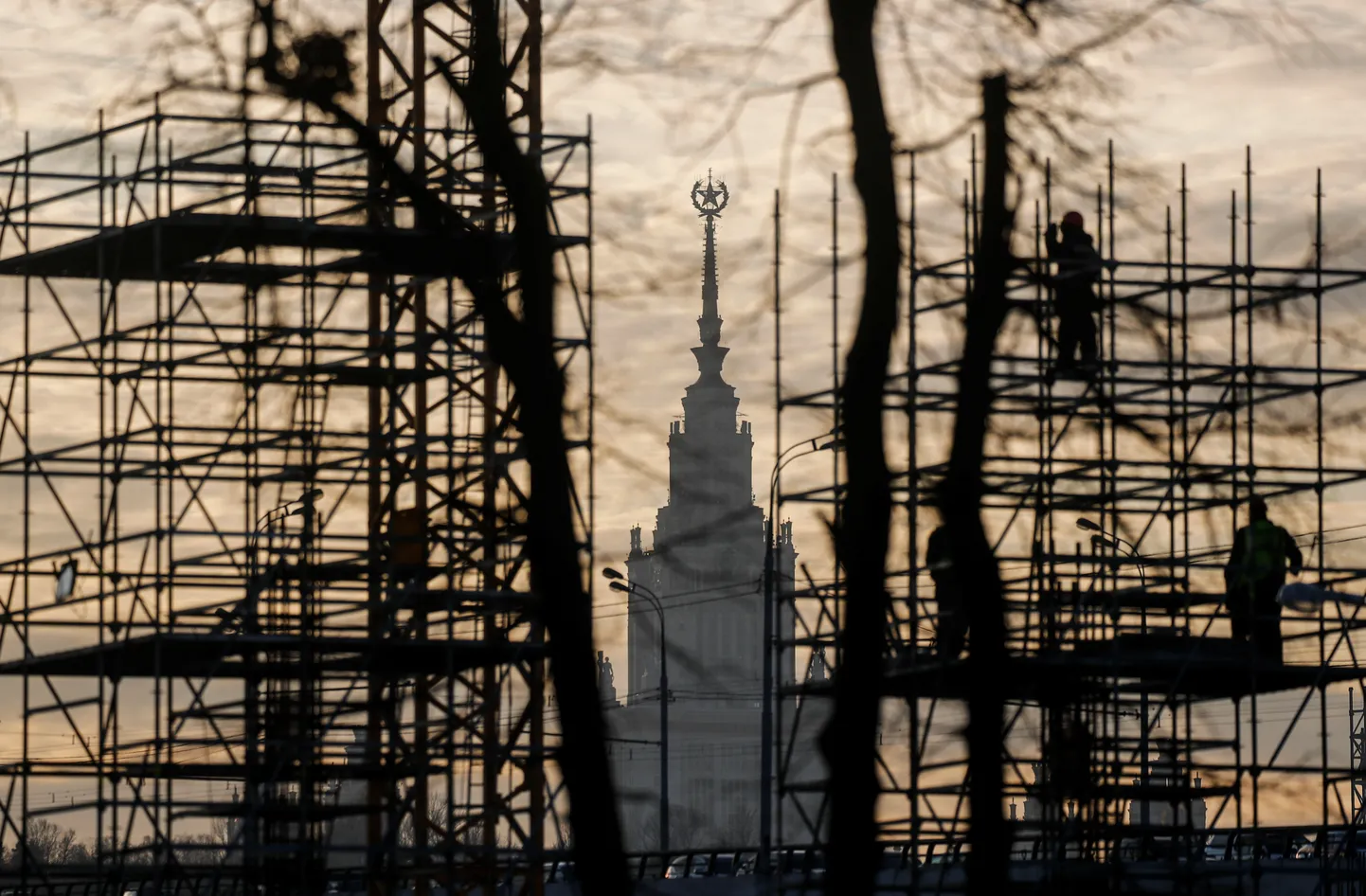 Construction workers are seen on scaffolds, with Moscow State University building in the background, in Moscow, Russia November 23, 2019. REUTERS/Maxim Shemetov