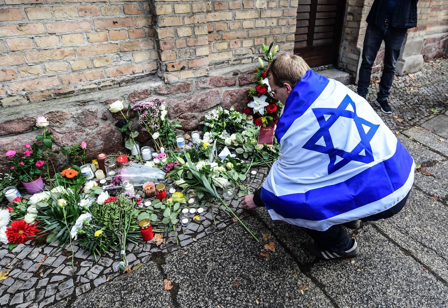 Iisraeli lipuga leinaja mälestamas kolmapäeval Saksamaal Halle linnas paremäärmusliku terroristi käe läbi hukkunud kaht inimest. 