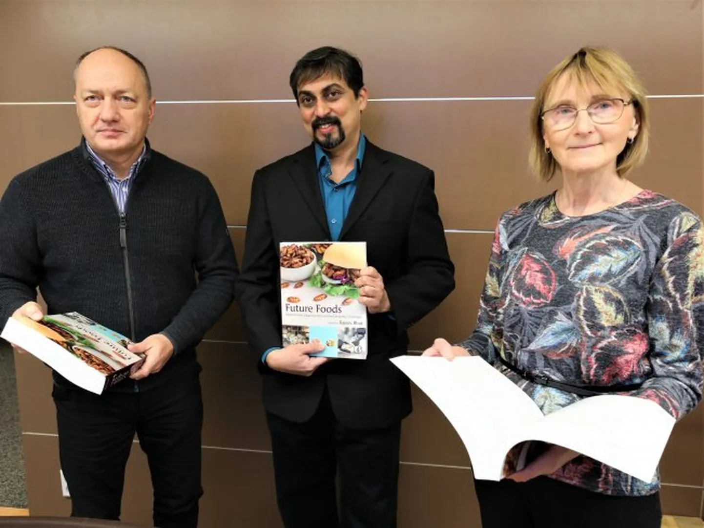 Raamatu toimetaja Rajeev Bhat, paremal teadusprorektor Ülle Jaakma, vasakul veterinaarmeditsiini ja loomakasvatuse instituudi direktor Toomas Tiirats.