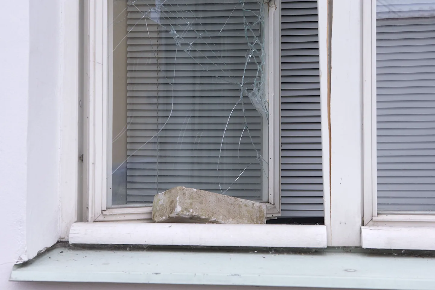 Разбитое кирпичом окно.