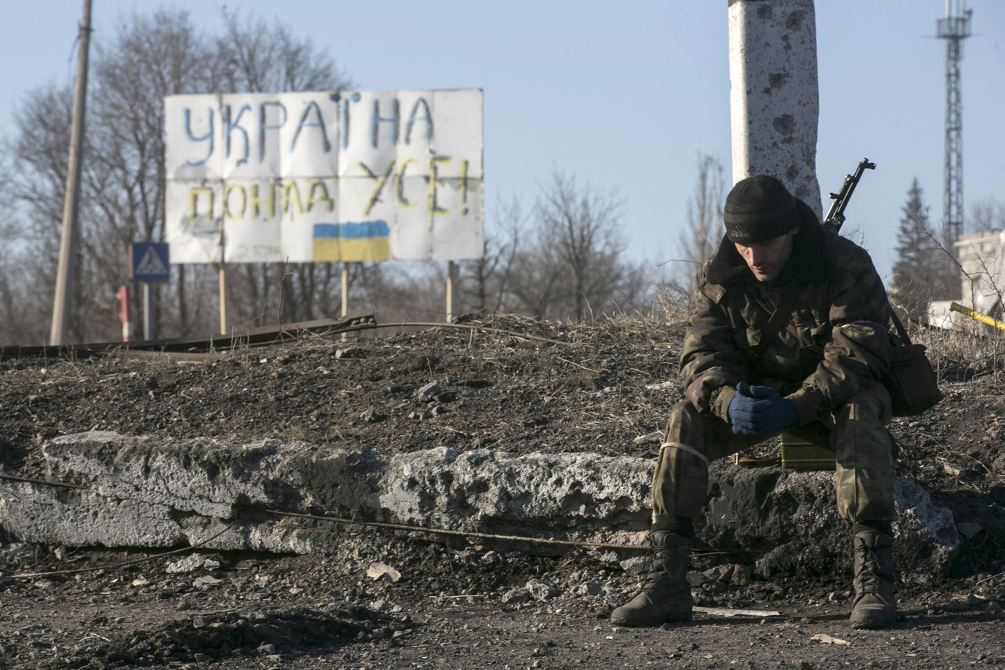 Isehakanud Donetski Rahvavabariigi võitleja istub plakati ees, millel on kirjutatud «Ukraina üle kõige», kontrollpunktis Debaltseves.