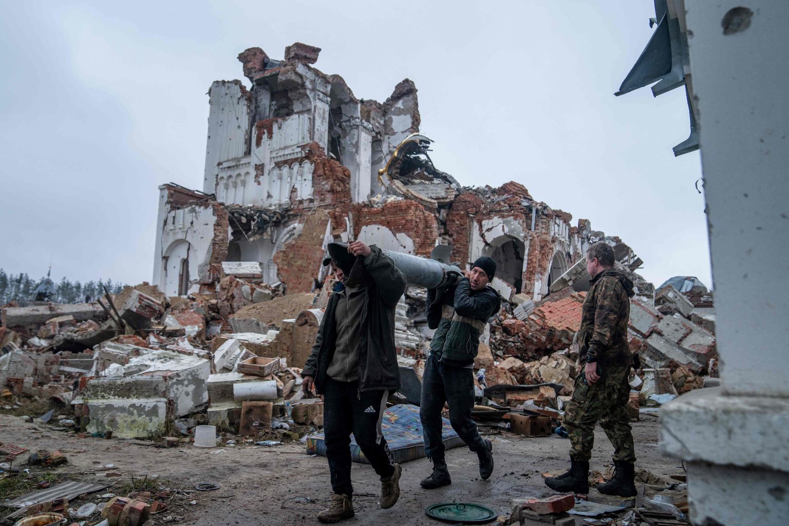 Vabatahtlikud kannavad Uragan tüüpi raketti, kui koristavad Donetski oblastis Dolõna külas sõjategevuses purustatud kiriku ümbrust.