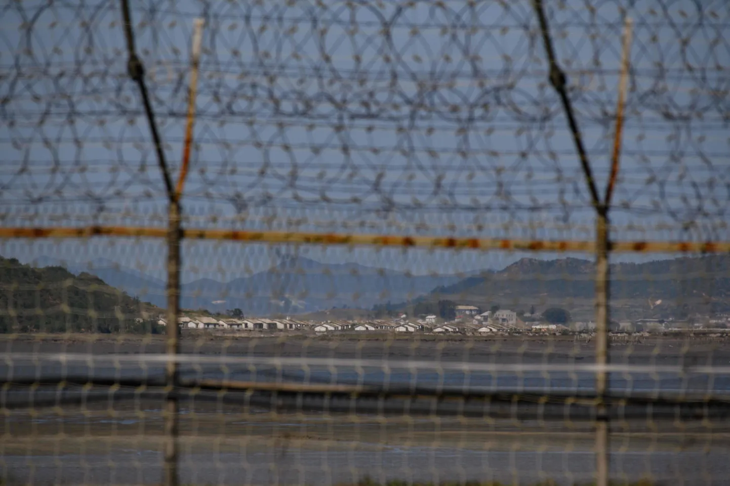 Vaade Põhja-Korea külale läbi demilitariseeritud tsooni piiritara.
