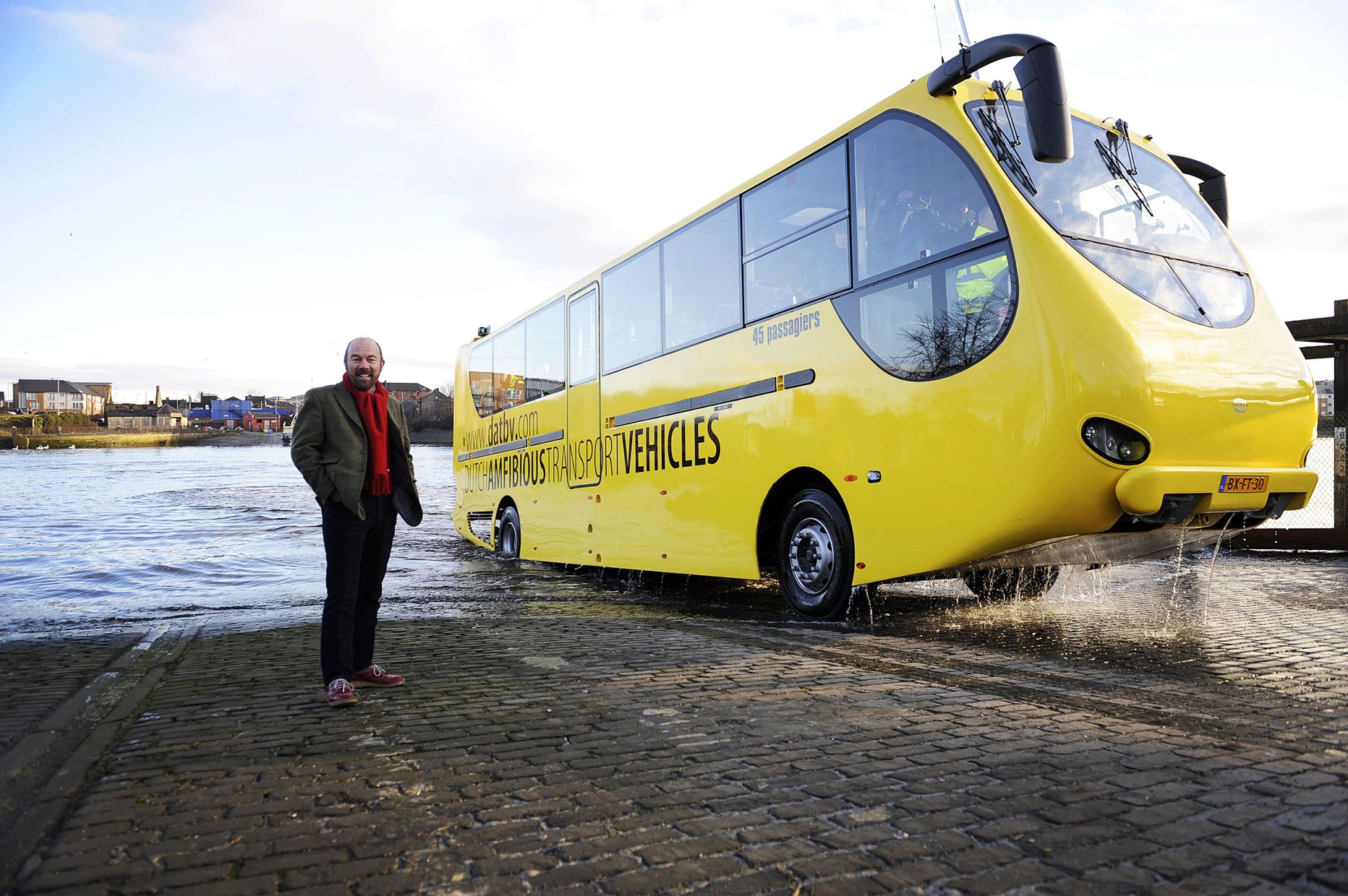 Brian Souter, Chief Executive of Stagecoach Group, poses for pictures as his company's 'amphibious bus' is trialed in the River Clyde near Glasgow, Scotland, on February 9, 2010. The GBP 700,000 (approx 797,600 euros/1m USD) 'amfibus', built in Holland, is designed to operate on water and roads, and is being trialed to replace the current ferry service and to link communities on the River Clyde. AFP PHOTO/ANDY BUCHANAN