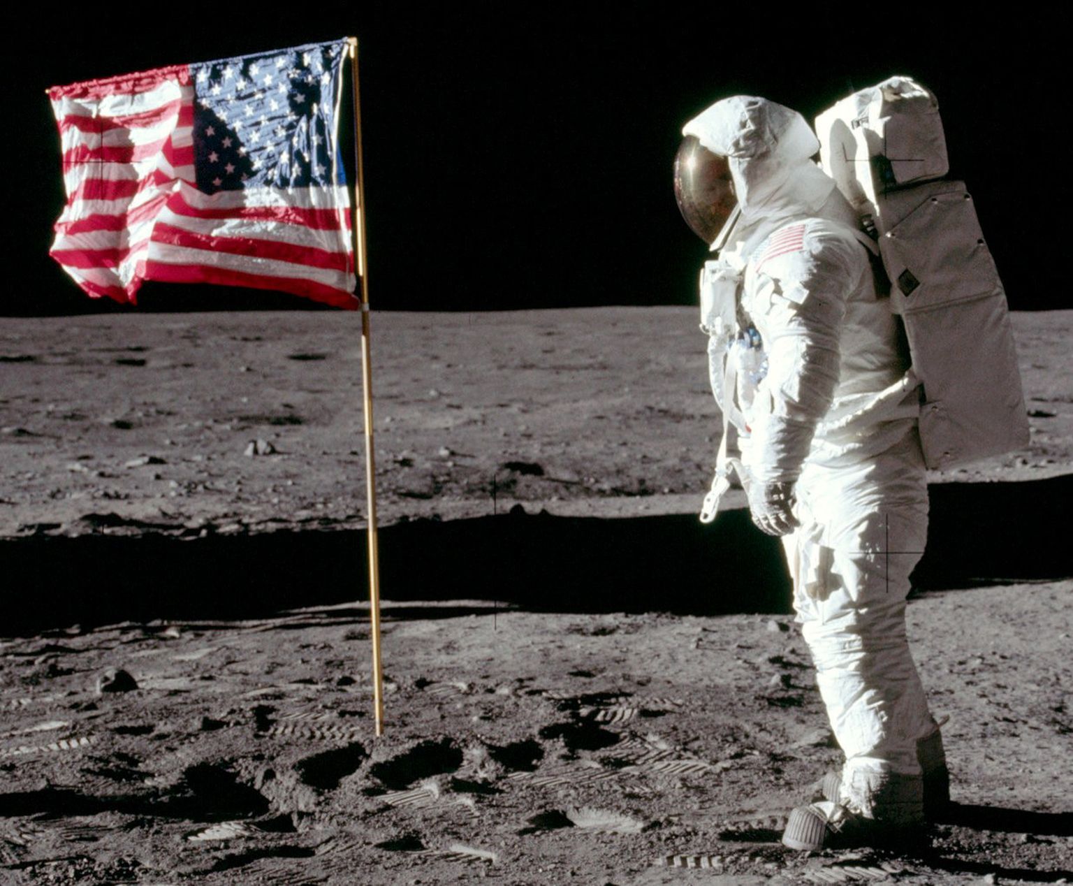 Американский астронавт Базз Олдрин после установки флага США на Луне смотрит на коллегу, первого человека на земле Нила Армстронга, который сделал это историческое фото. Луна, июль 1969 года.