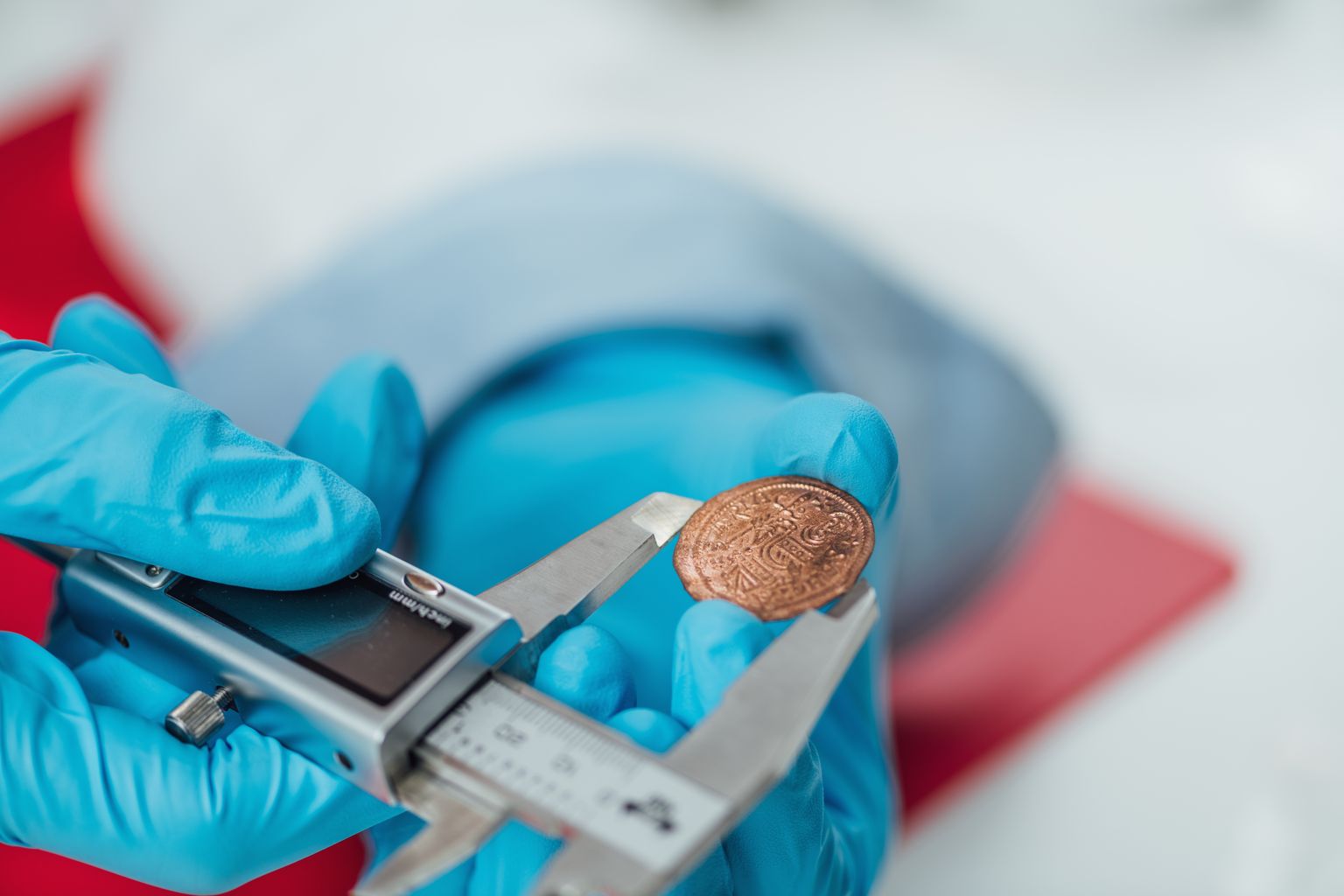 Teadlane uurimas vana münti. Pilt on illustreeriv