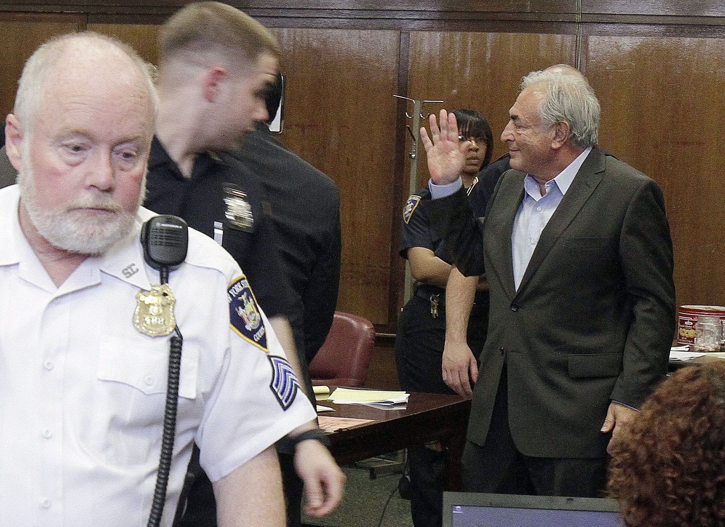 Dominique Strauss-Kahn lehvitab oma perekonnale kohtust lahkumisel.