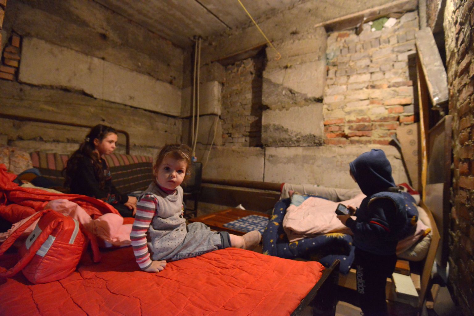 Donetskis elava pere lapsed, 11-aastane Anja (vasakul), nelja-aastane Alesia ja samavana Mikhail varjunud pommitamise eest maja keldrisse