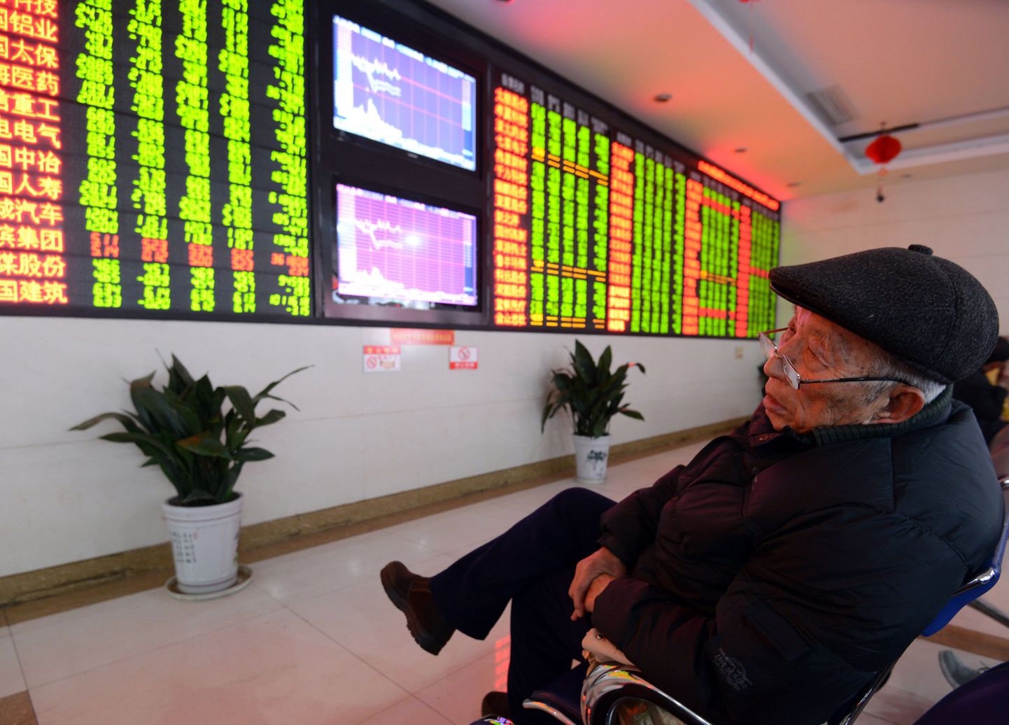 Aktsiakaupleja tukub Hiinas Fuyangi linnas börsimaaklerifirmas hindu kuvava ekraani ees.
