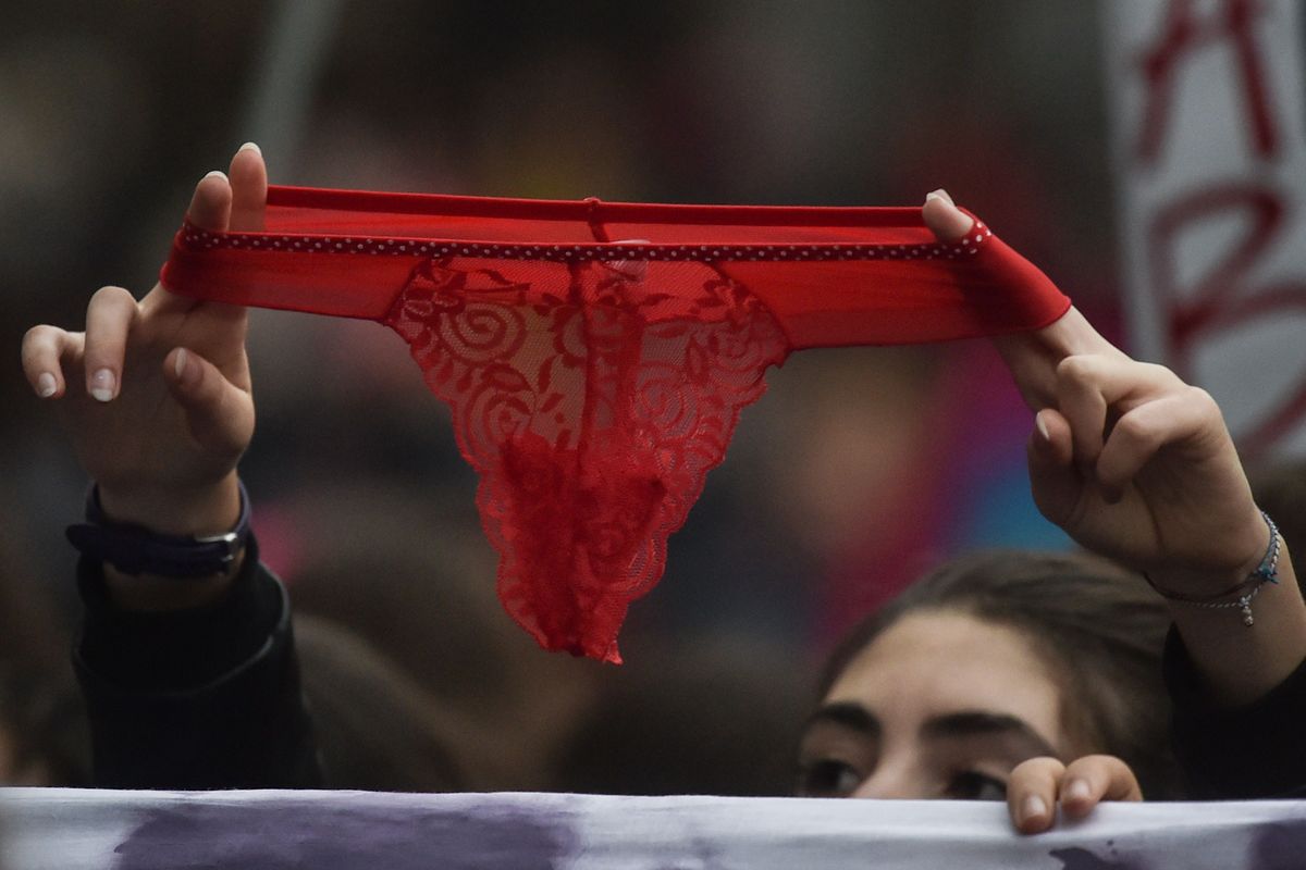 2018. gada 24. novembris, Roma, Itālija. Rādot sarkanas mežģīņu apakšbikses, sieviete pauž atbalstu demonstrācijā pret seksuālu vardarbību pret sievietēm. 