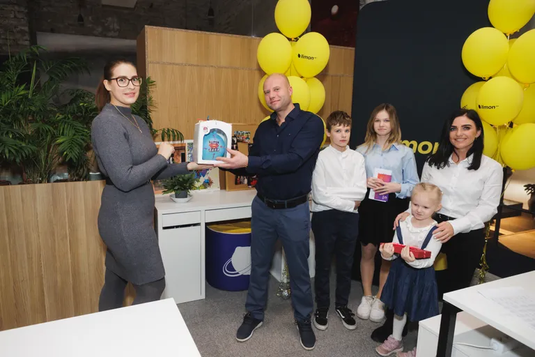 Кондитер Ксения Малышева вручает шоу-торт в форме шара победителю фотоконкурса.