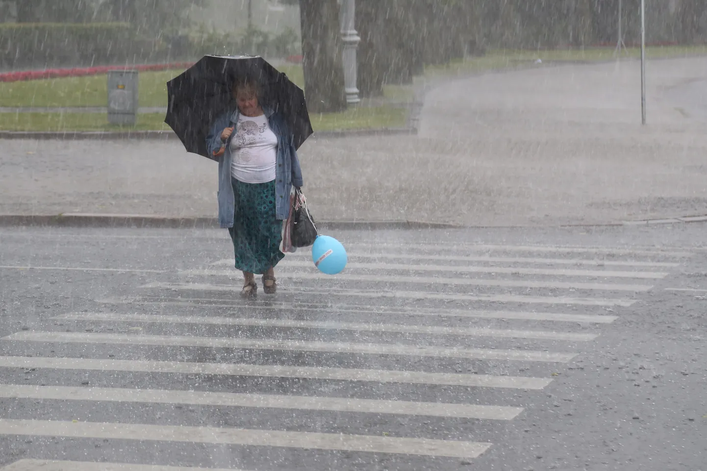 Sievietes ar lietussargu negaisa laikā.