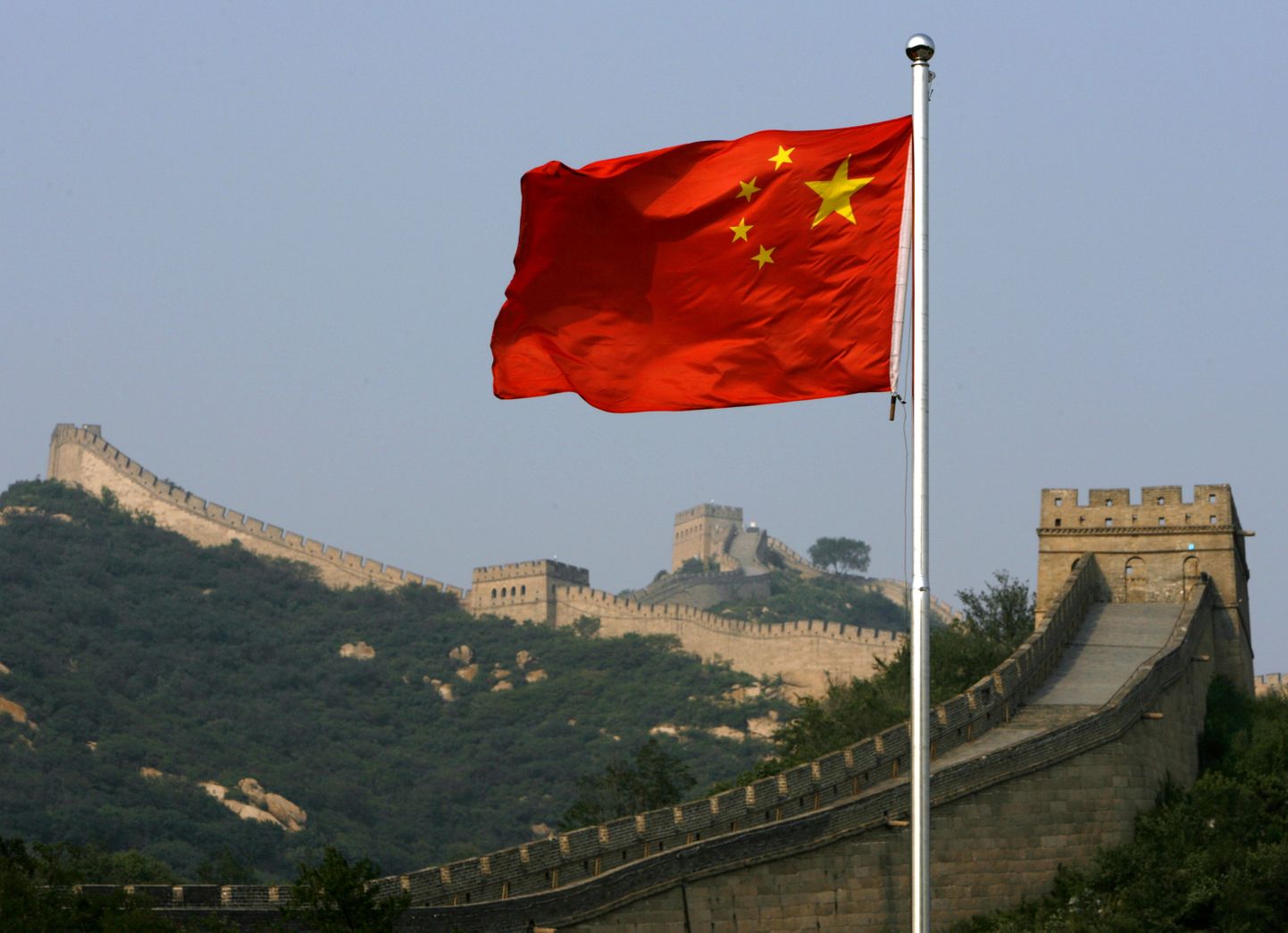 Ķīnas karogs uz Lielā Ķīnas mūra fona.
