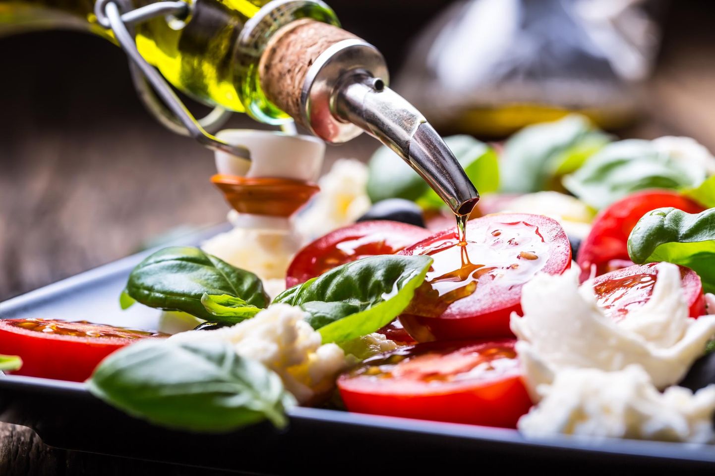 Itaalia kombel: lihtne salat tomatist ja mozzarella juustust, mida täiendavad väärisoliiviõli ja basiilik. Lisamaitset annavad sool ja pipar. FOTO: Shutterstock