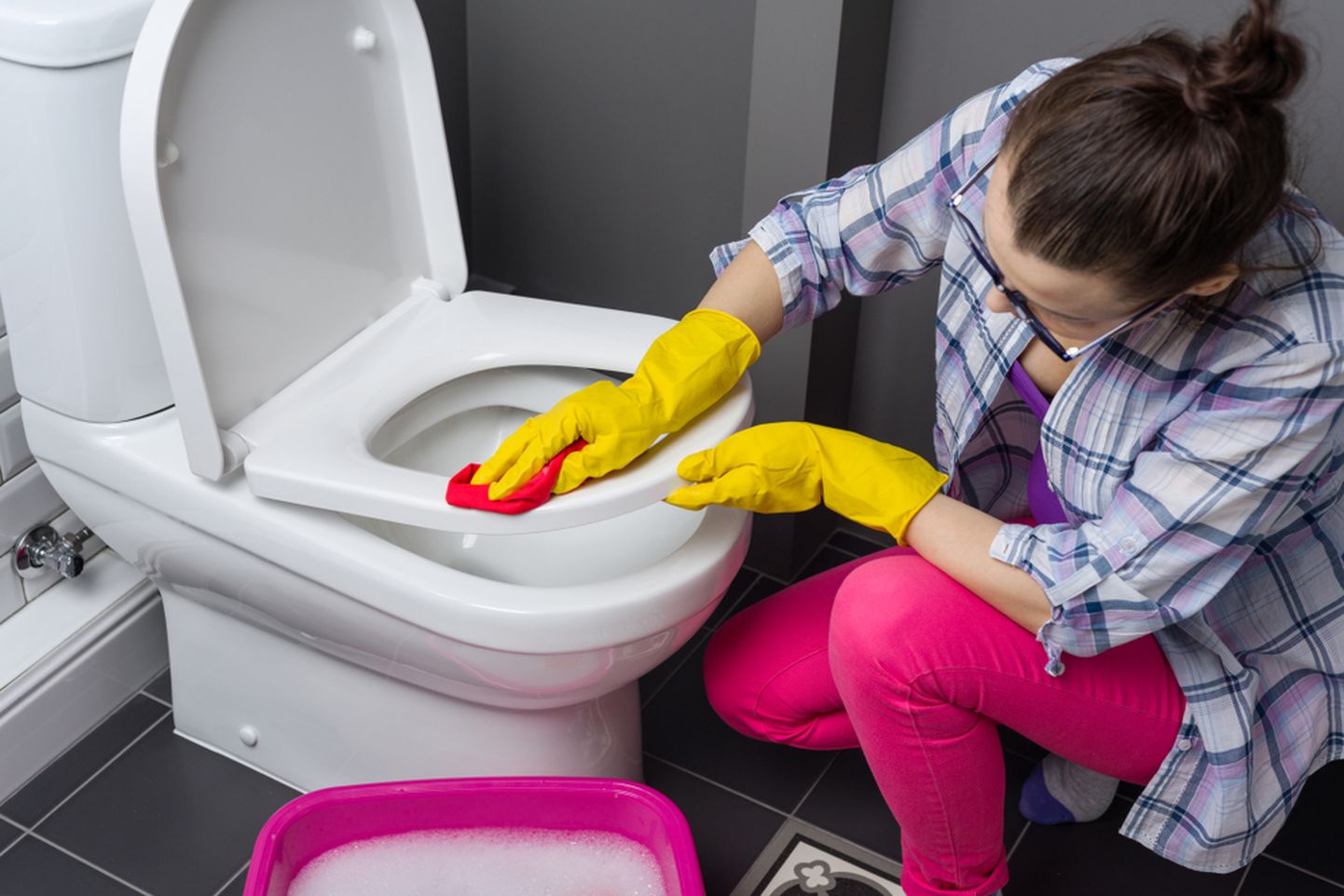Naine puhastab WC-potti.