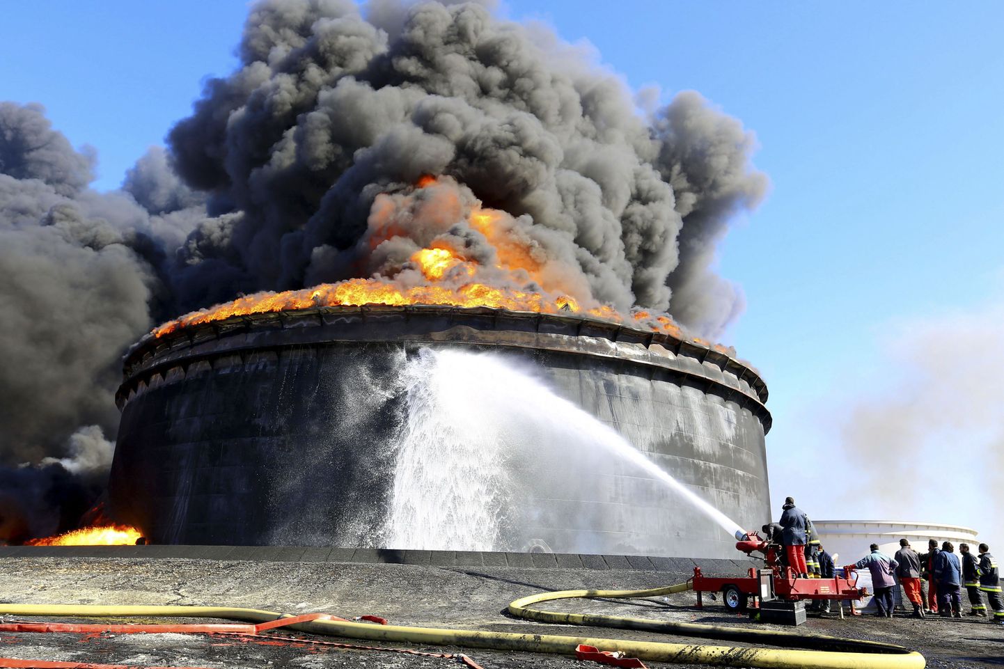 Tuletõrjujad üritavad kustutada raktetitabamuse saanud naftareservuaari Ras Lanufi sadamas Liibüas. Vaenupoolte tegevus on nafta ekspordi Liibüa sadamatest peatanud, kuid maailmaturgudel jätkab nafta hind sellest hoolimata kukkumist.