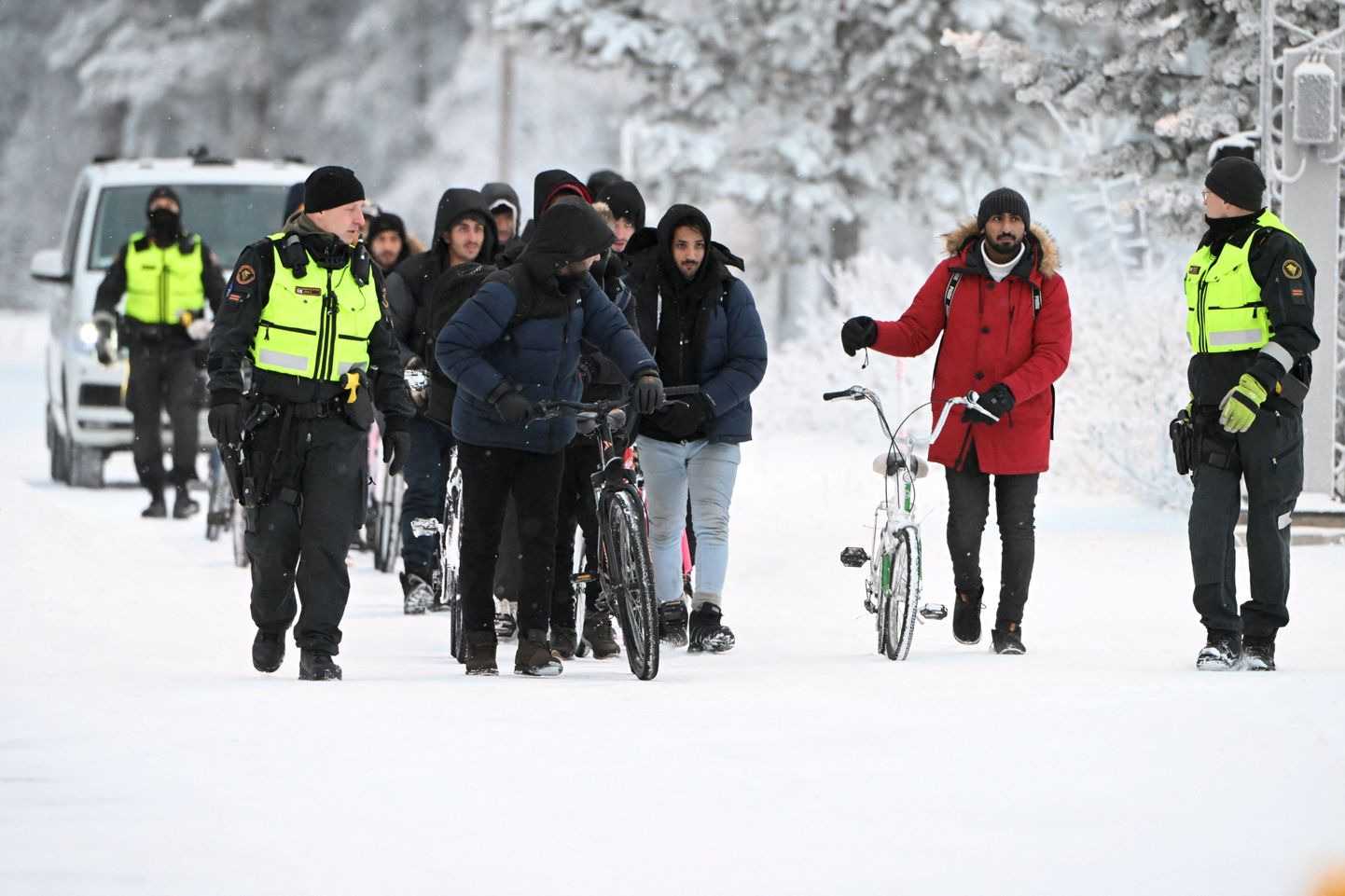 Soome piirivalvurid eskordivad Salla piiripunktis jalgratastega migrante.