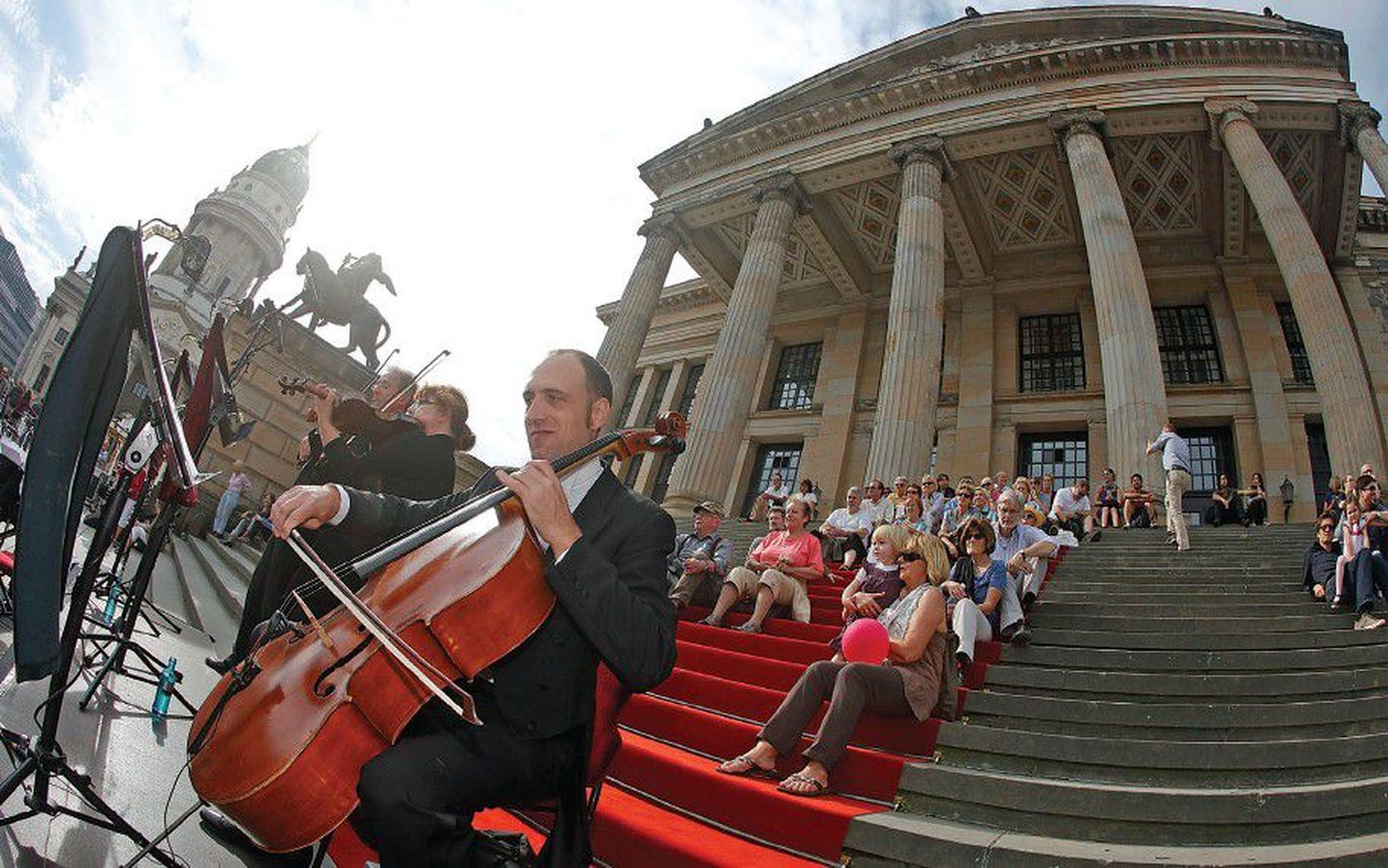 Люди слушают выступление музыкантов во время празднования воссоединения Германии в центре Берлина 3 октября 2011 года.