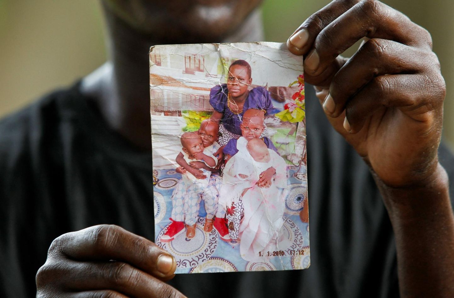 Steven Mwiti näitab fotot naisest ja neljast lapsest, kes on tõenäoliselt surnud. 