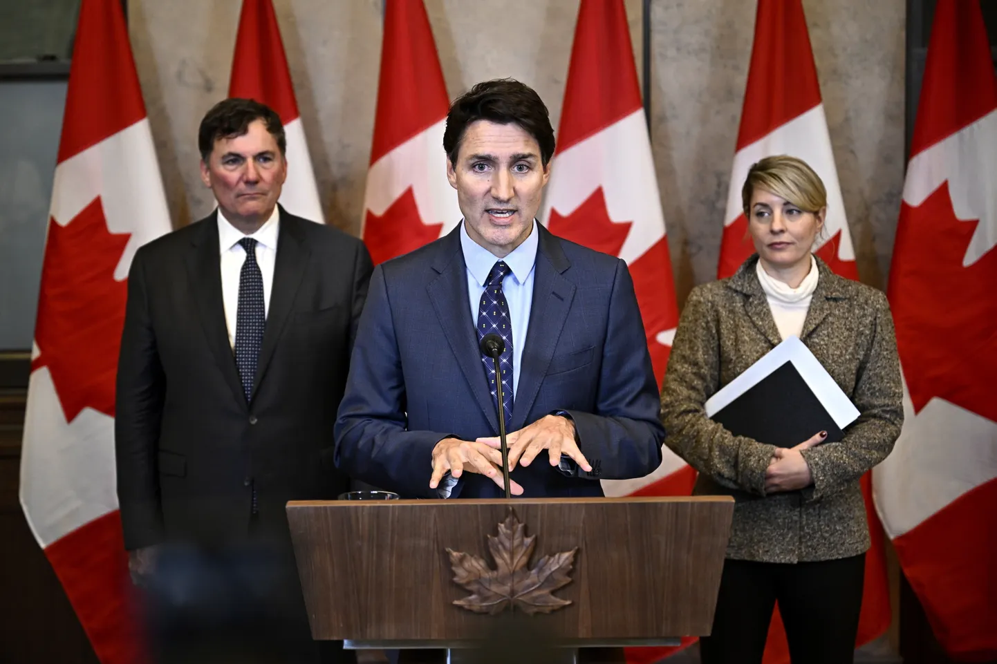 Kanada peaminister Justine Trudeau koos avaliku julgeoleku, demokraatlike institutsioonide ja valitsustevaheliste suhete ministri Dominic LeBlanci (vasakul) ja välisminister Melanie Jolyga rääkimas India kriminaalsest tegevusest Kanadas 14. oktoobril 2024. aastal.