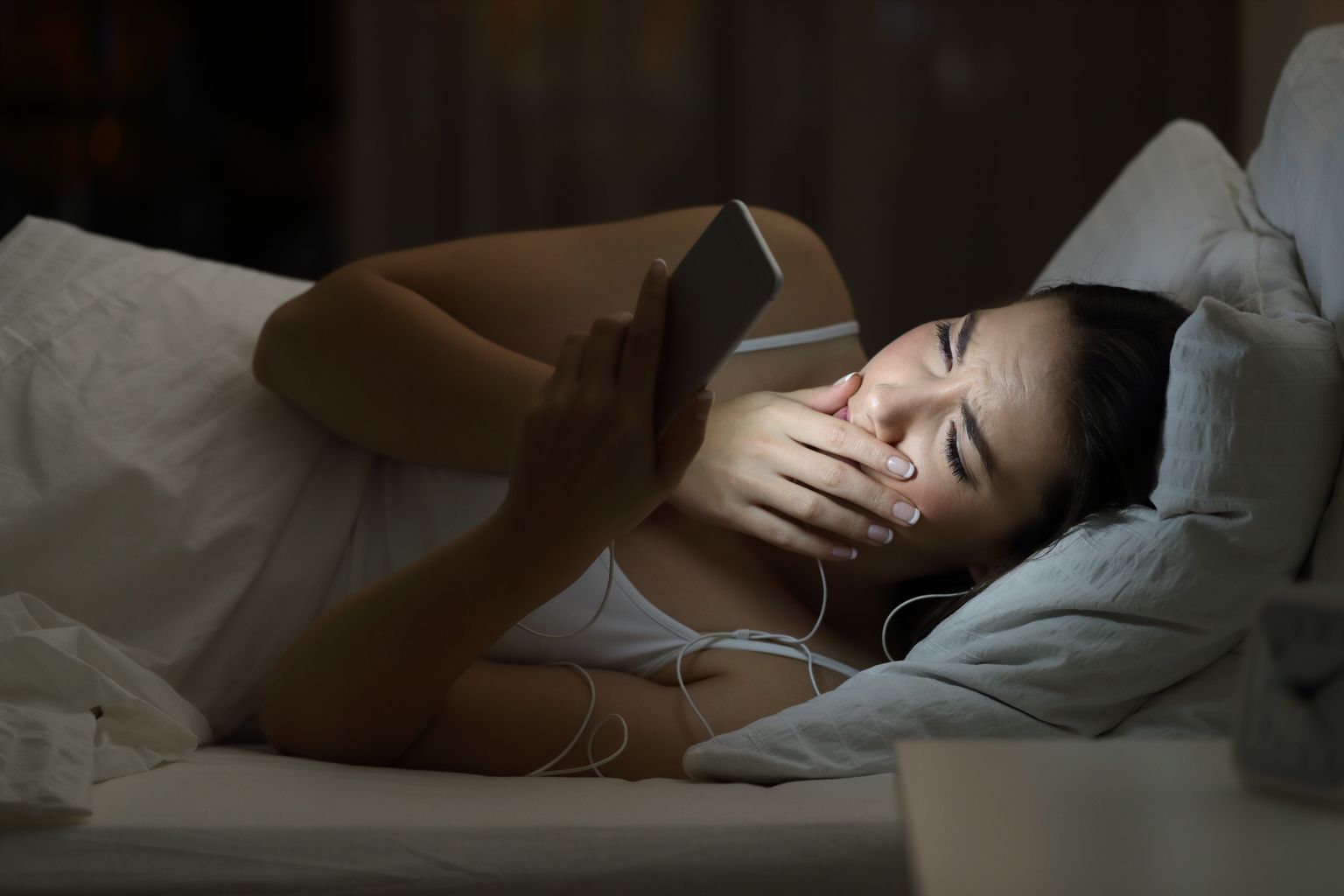 Worried woman watching bad content in a smat phone in the night