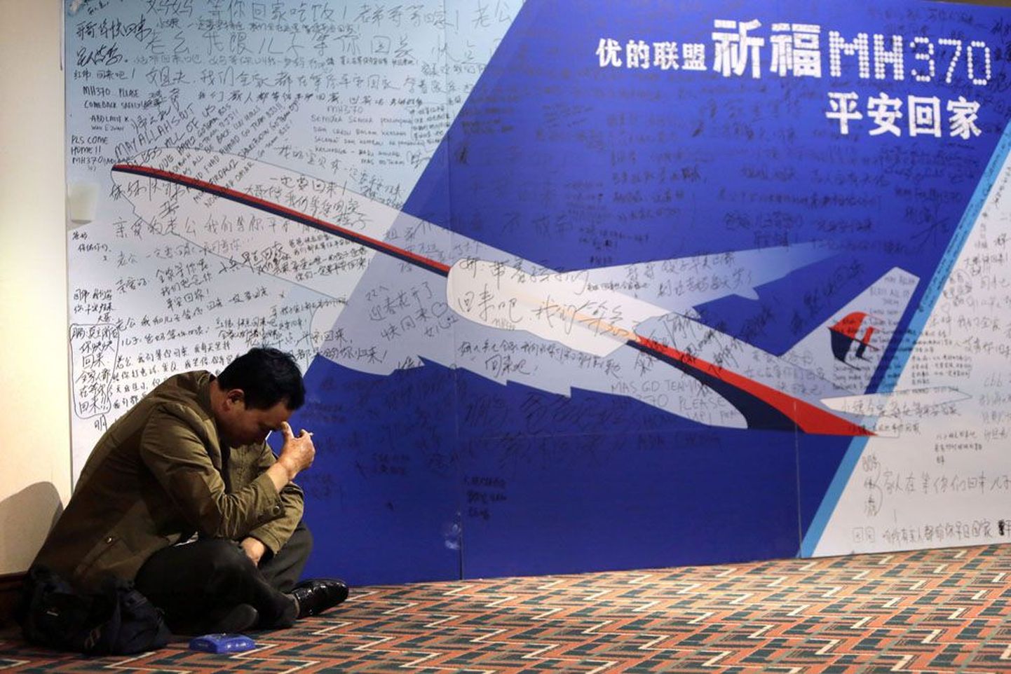 Pildil olev hiina mees ootab uudiseid lennuki pardal viibinud noorema venna kohta.