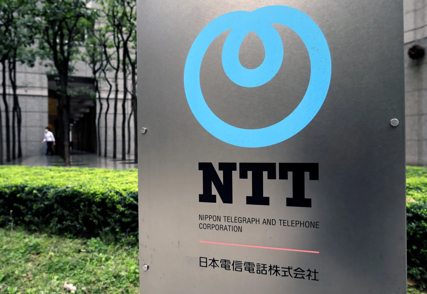 The logo of NTT (Nippon Telegraph and Telephone Corporation) is displayed at the company office in Tokyo.
