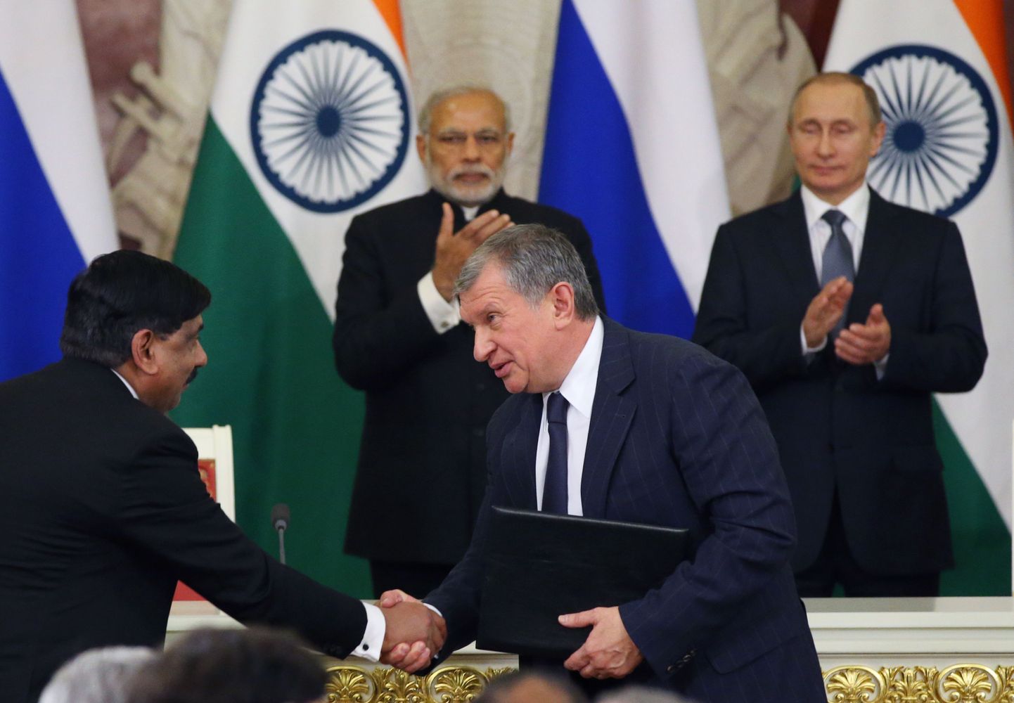 Indian Oil Corporationi ja Rosnefti juhid Ashok Balasubramanian (vasakul) ja Igor Setšin mullu detsembris Moskvas allakirjutatud eellepingu dokumente vahetamas. Taamal jälgivad ärimehi India peaminister Narendra Modi ja Venemaa president Vladimir Putin.