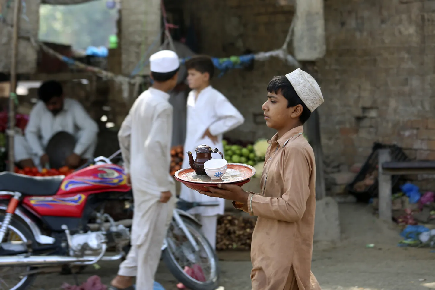 Pakistani poiss teed serveerimas.