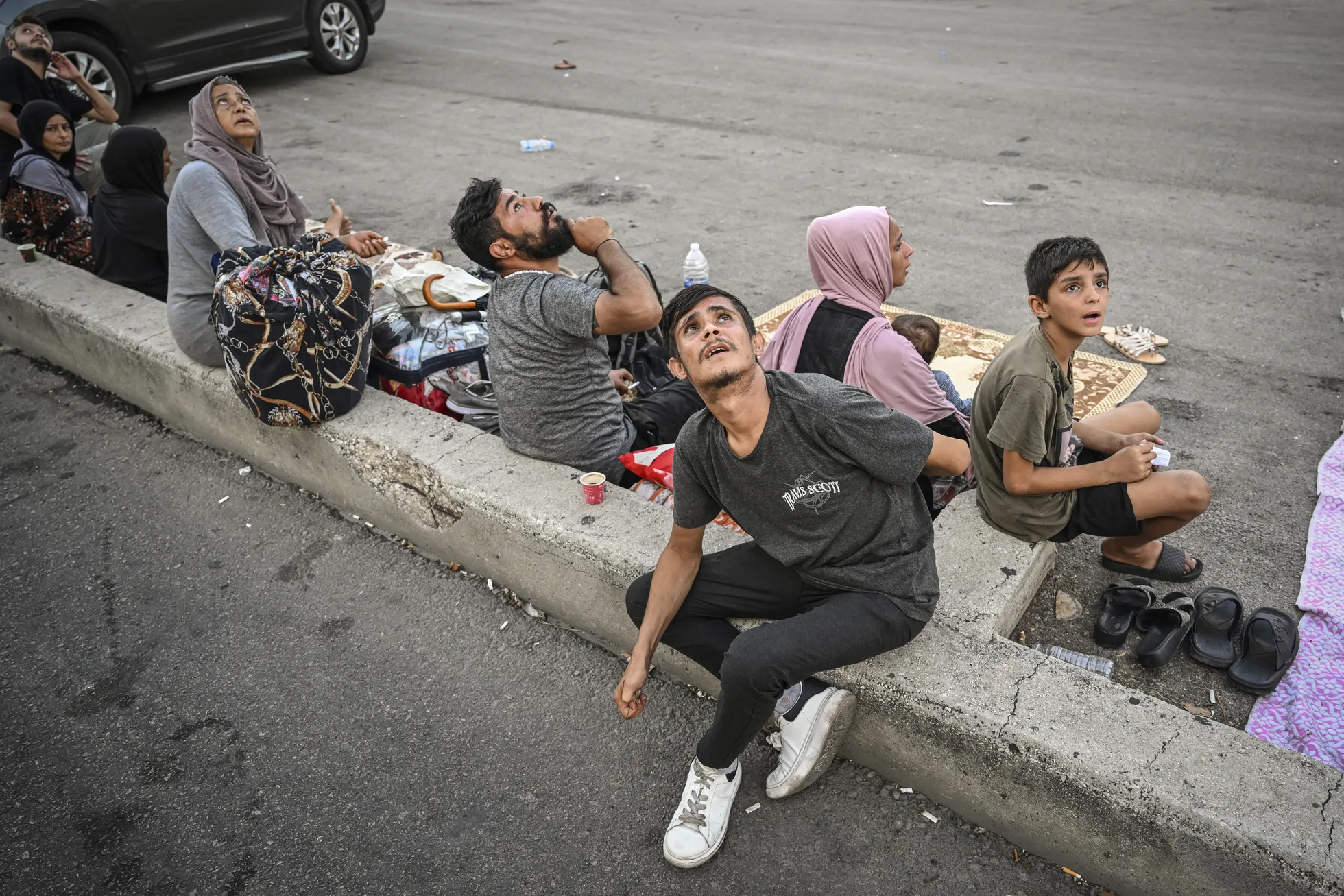 Inimesed vaatavad ärevalt üles Iisraeli droonirünnaku ajal, otsides varju hoonetest eemal Beiruti Dahiyeh’ linnaosas. Hävituslennukid ja droonid lendavad sageli madalal, tekitades hirmu ja ärevust. Liibanon, 29. september 2024. Lääne-, Kesk- ja Lõuna-Aasia, üksikfotod.