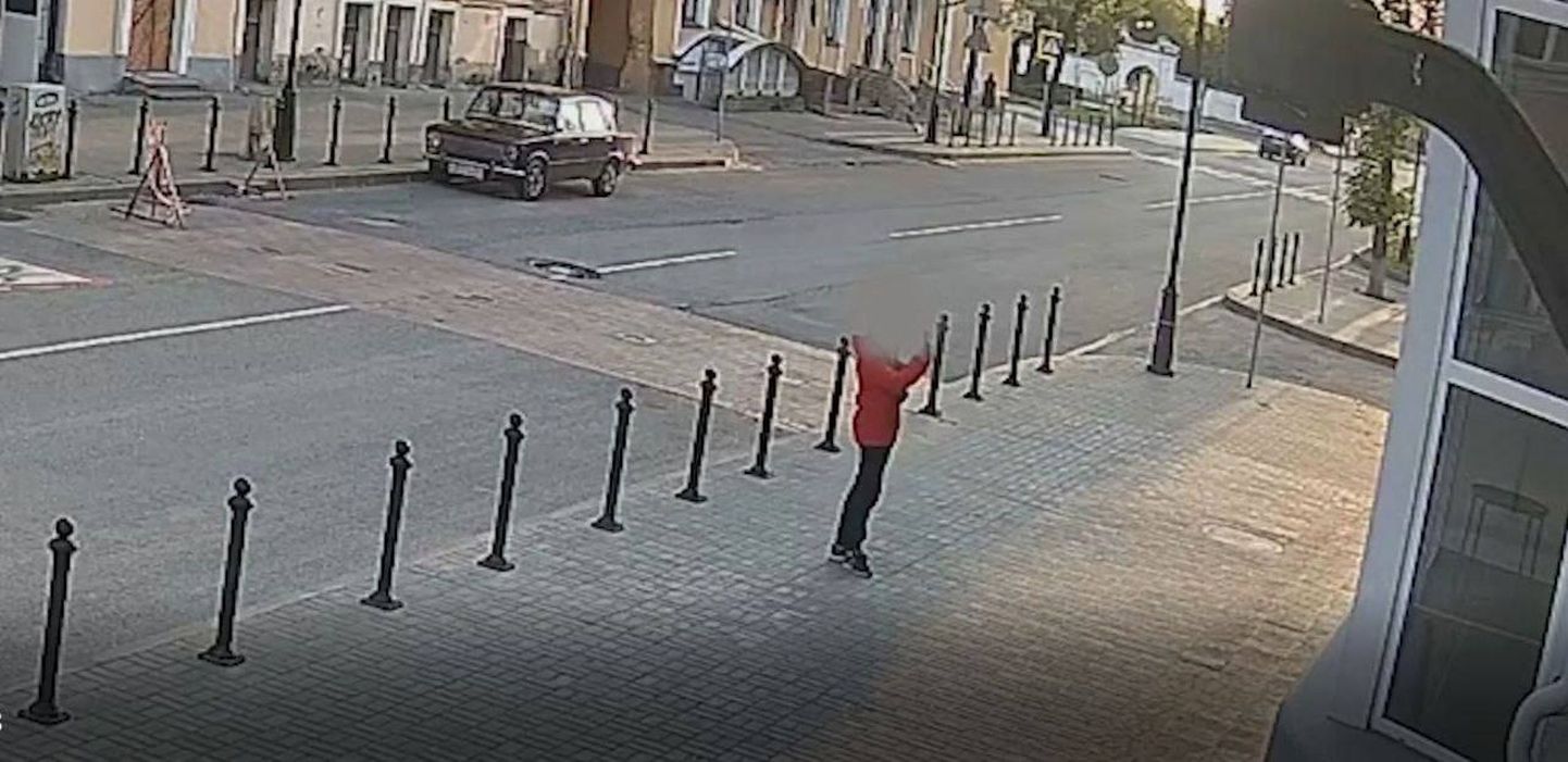 Александр Ежов, житель Пскова, был наказан за распространение антивоенных листовок. На снимке он фотографирует листовку, наклеенную на стену дома.