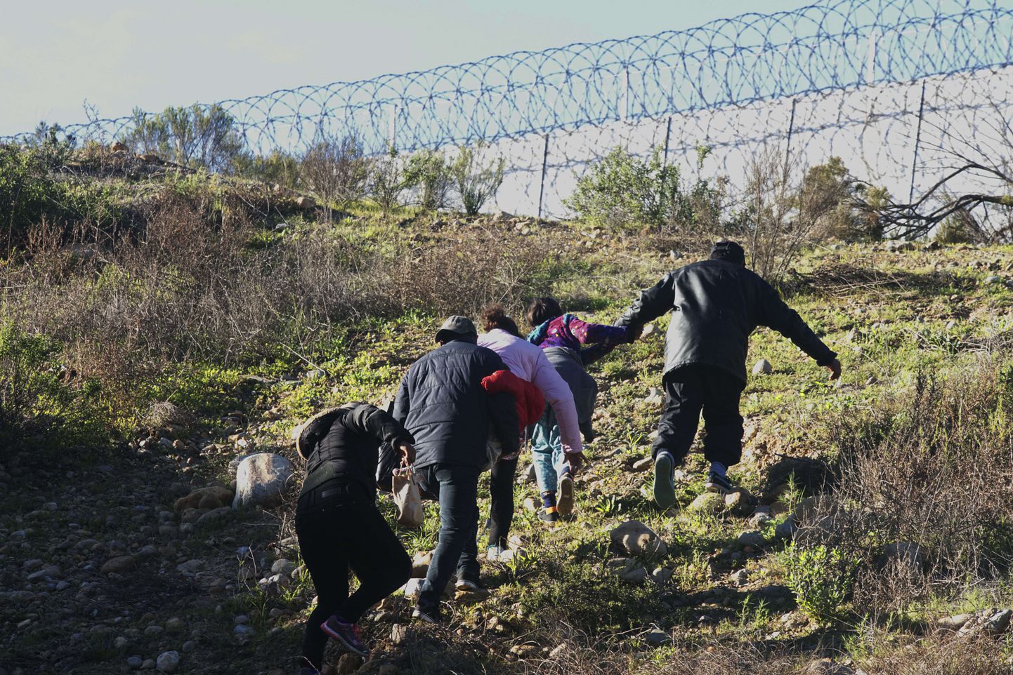 Hondurasest pärit migrandid jooksevad Mehhikot ja USAd eraldava piiritara suunas Tijuanas Mehhikos 6. jaanuaril 2019.