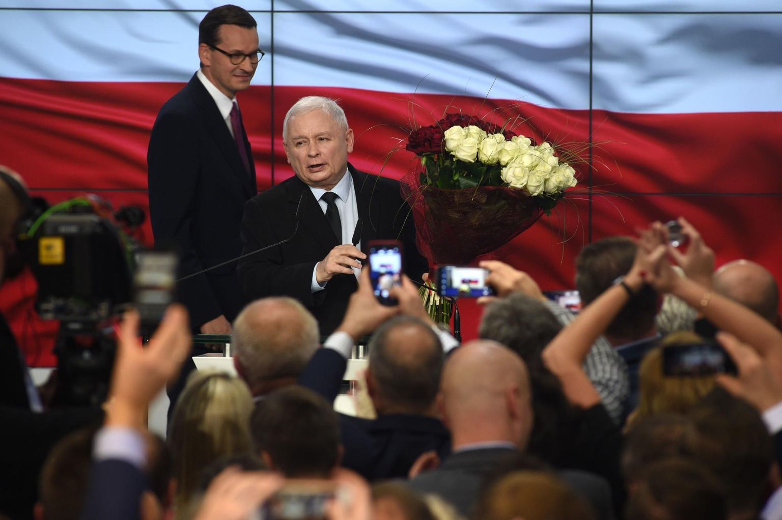 Õiguse ja Õigluse (PiS) esimees Jarosław Kaczynski ja peaminister Mateusz Morawiecki (tagaplaanil) tähistamas üleeile hilisõhtul võitu Poola parlamendivalimistel.