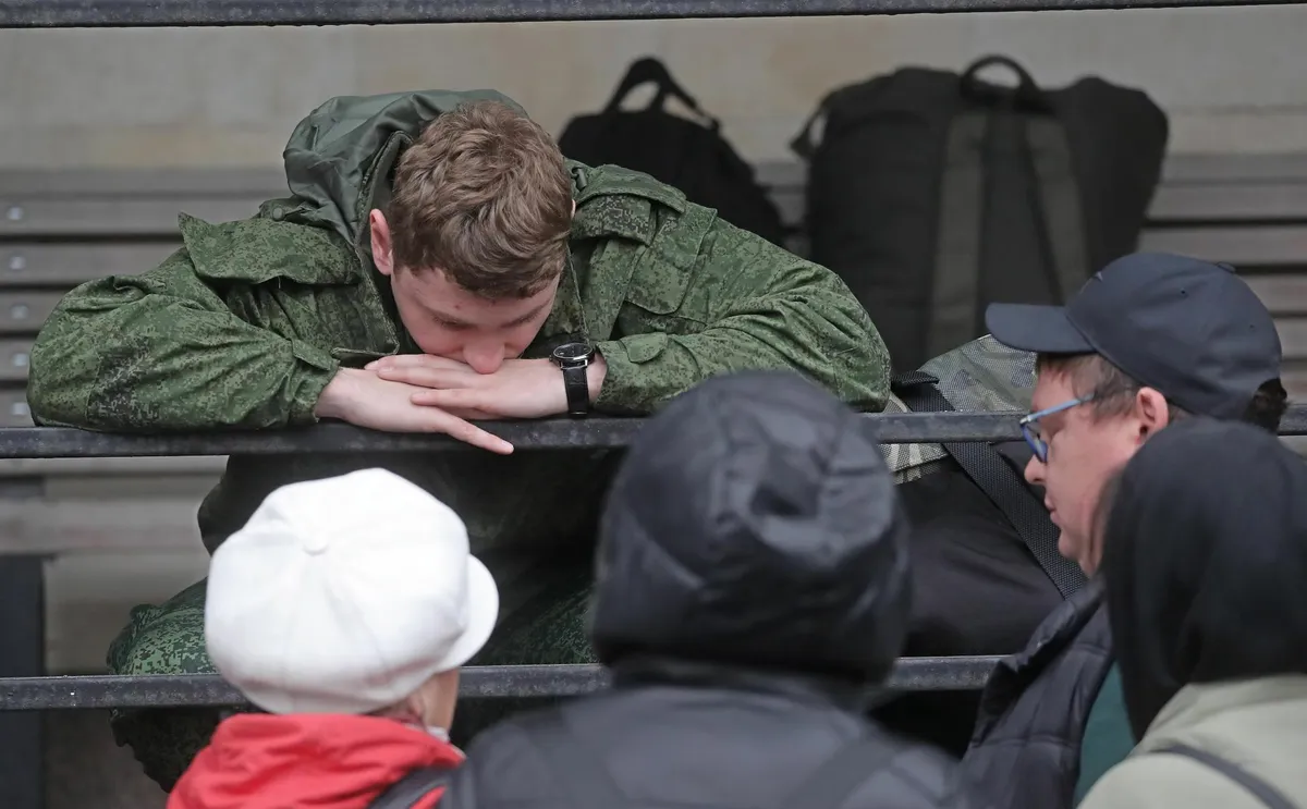 A man sent from Russia to Ukraine as part of the so-called partial mobilization initiated in September 2022 bids farewell to his loved ones at a gathering point in Moscow on October 6.